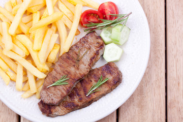 grilled steak with french fries and salad