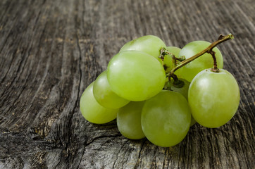 A bunch of green grapes isolated on wood texture