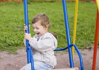 little cute boy on swing outside