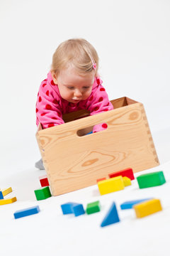 Kind kramt in Holzkiste