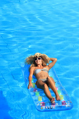 Beautiful young woman relaxing in a swimming pool