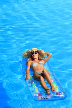 Beautiful young woman relaxing in a swimming pool