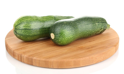 Fresh zucchini on chopping board isolated on white