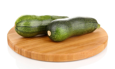 Fresh zucchini on chopping board isolated on white