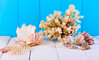 Decor of seashells on wooden table on blue wooden background