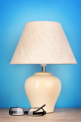table lamp and glasses on blue background