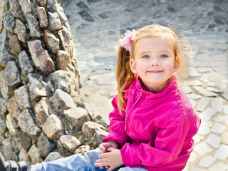 Outdoor portrait  of cute sitting little girl