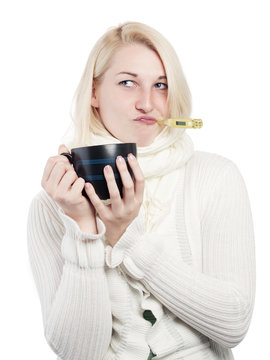 Young woman with fever thermometer and cup of tea - isolated