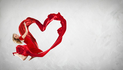 Dancing young woman with flying fabric