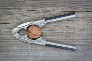 Nutcracker and walnuts on wooden texture coating.