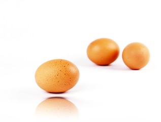 Set of three brown eggs with reflection