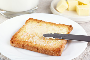 Breakfast. Glass with milk and toasts with butter