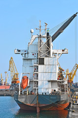 Bulk cargo ship under port crane bridge, Odessa, Ukraine