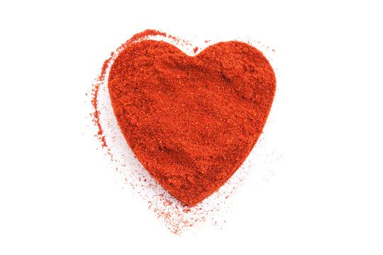 Pile of ground Paprika isolated in heart shape on white backgrou