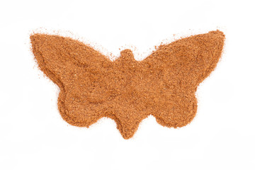 Heap of ground Cinnamon isolated in butterfly shape on white bac