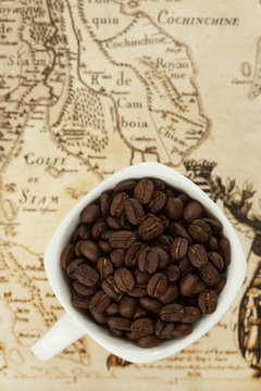 Coffee beans in a cup on siam map background