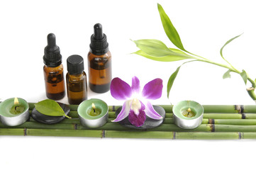 Obraz na płótnie Canvas Set of fresh leaf and massage oil with orchid on bamboo grove