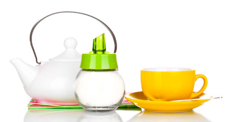 Yellow cup with saucer and teapot isolated on white