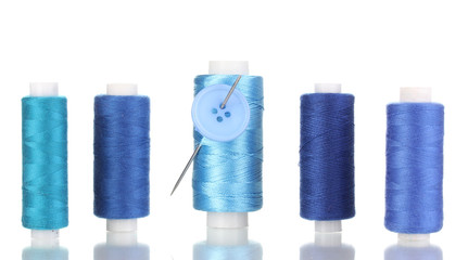 Many blue bobbin with needle and buttons isolated on white