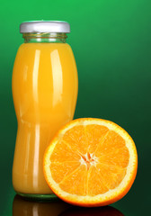 Fototapeta na wymiar Pyszny sok pomarańczowy w butelkę i pomarańczowy obok