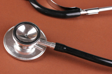 Stethoscope on brown background