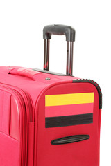 red suitcase with sticker with flag of Germany isolated on