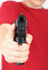 Teenager with a gun in his hand, focus on the gun