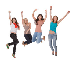 Four young woman jumping for joy