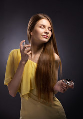 beautiful young woman spraying perfume