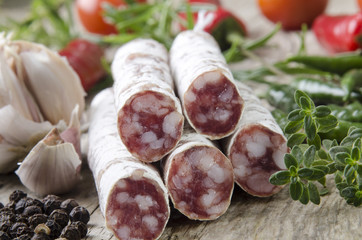 hausgemachte Salami mit Gemüse und Gewürzen auf einem Holzbret