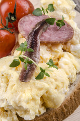 Rührei mit Salami, Sardellen und Tomaten auf Brot
