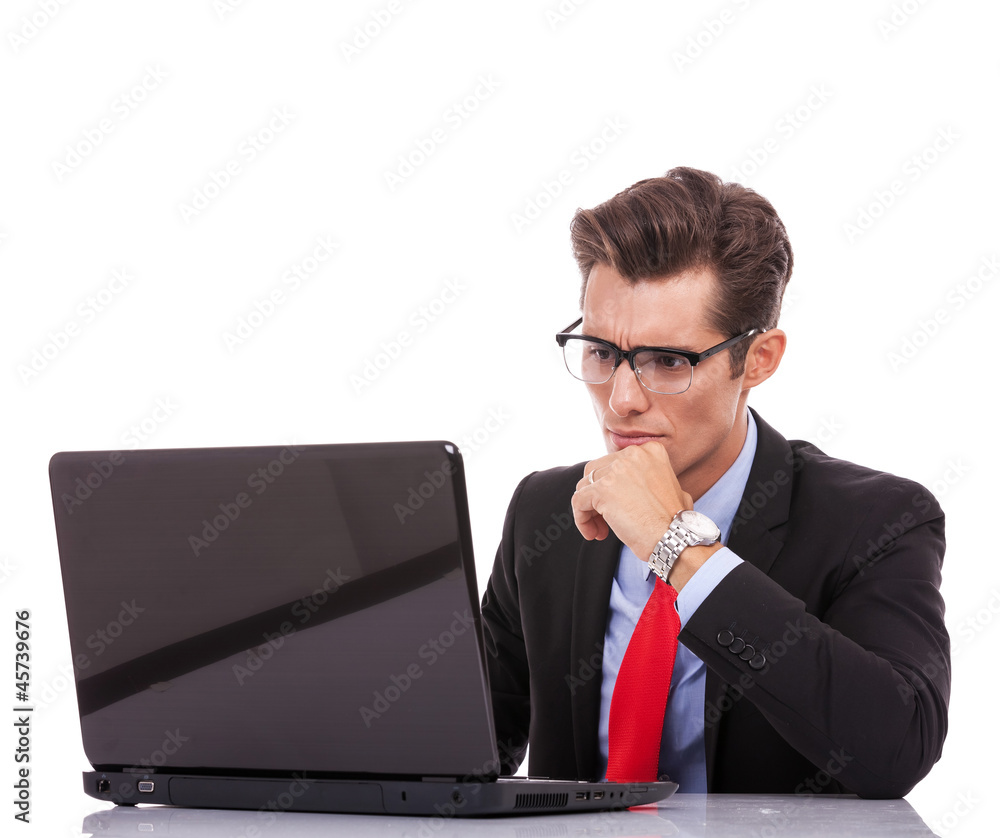 Wall mural young business man looking serious at laptop