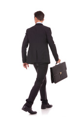 back view of a walking business man with briefcase