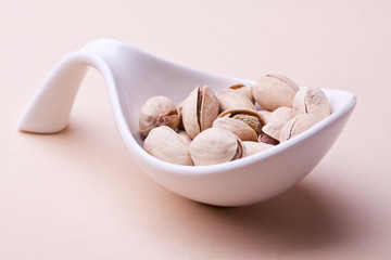 pistachios in a bowl. closeup on pastel background