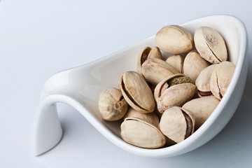 pistachios in a bowl. closeup on white background