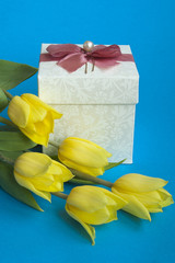 Box with a gift and yellow tulips