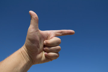 man's hand against the blue sky