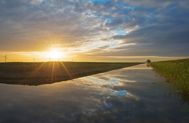 Canal in sunlight at dawn in fall
