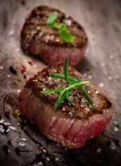 Grilled bbq steaks on wooden background