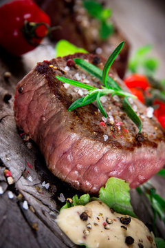 Medium grilled bbq steak with fresh herbs and tomatoes