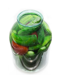 salted cucumber and tomatoes in a jar on a white background