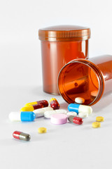 Pills pouring out of the brown bottle on isolated background