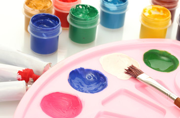 Tubes with colorful watercolors and jars with gouache and