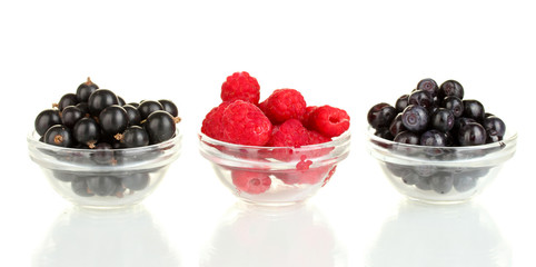 Fresh berries in transparent bowls isolated on white