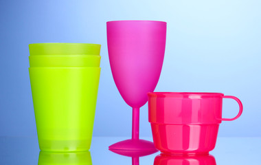 Bright plastic tableware on blue background