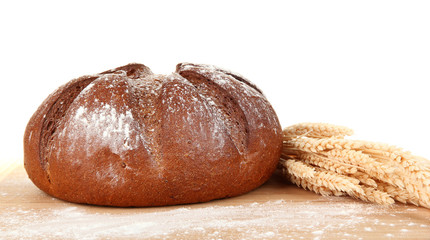 Homemade whole bread on wooden cutting board close-up