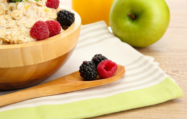 tasty oatmeal with berries and glass of juice, on wooden table
