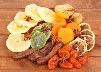 Dried fruits with anise stars on wooden background