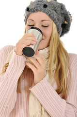 Junge Frau in Winterkleidung trinkt Kaffee