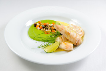 Fish fillet with sauce and vegetables on a plate
